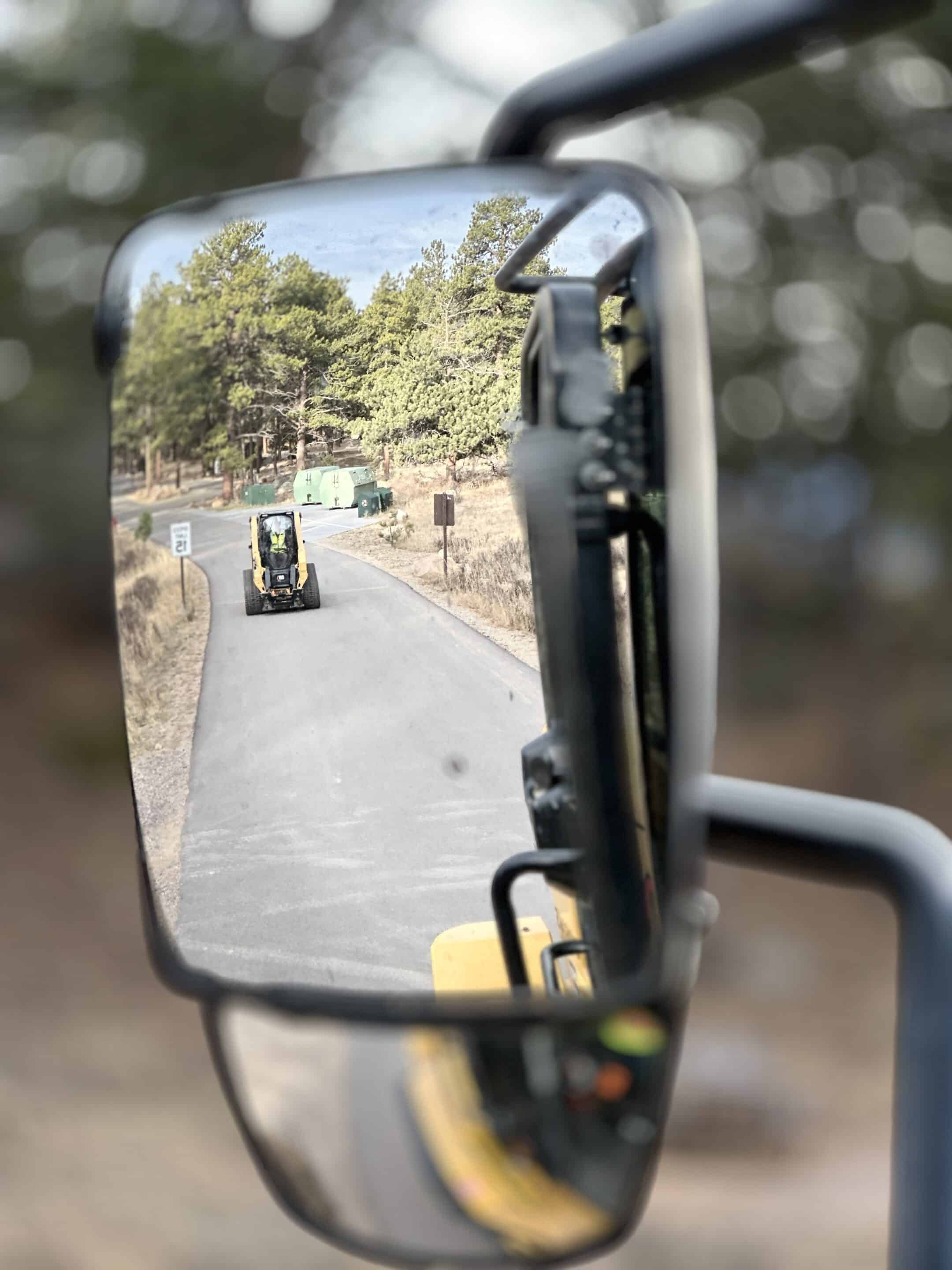 Reflected view of a construction vehicle in a truck mirror.
