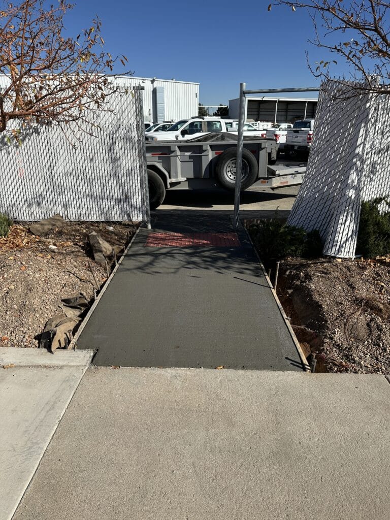 John Deere dump truck on a rocky path in a pine forest.