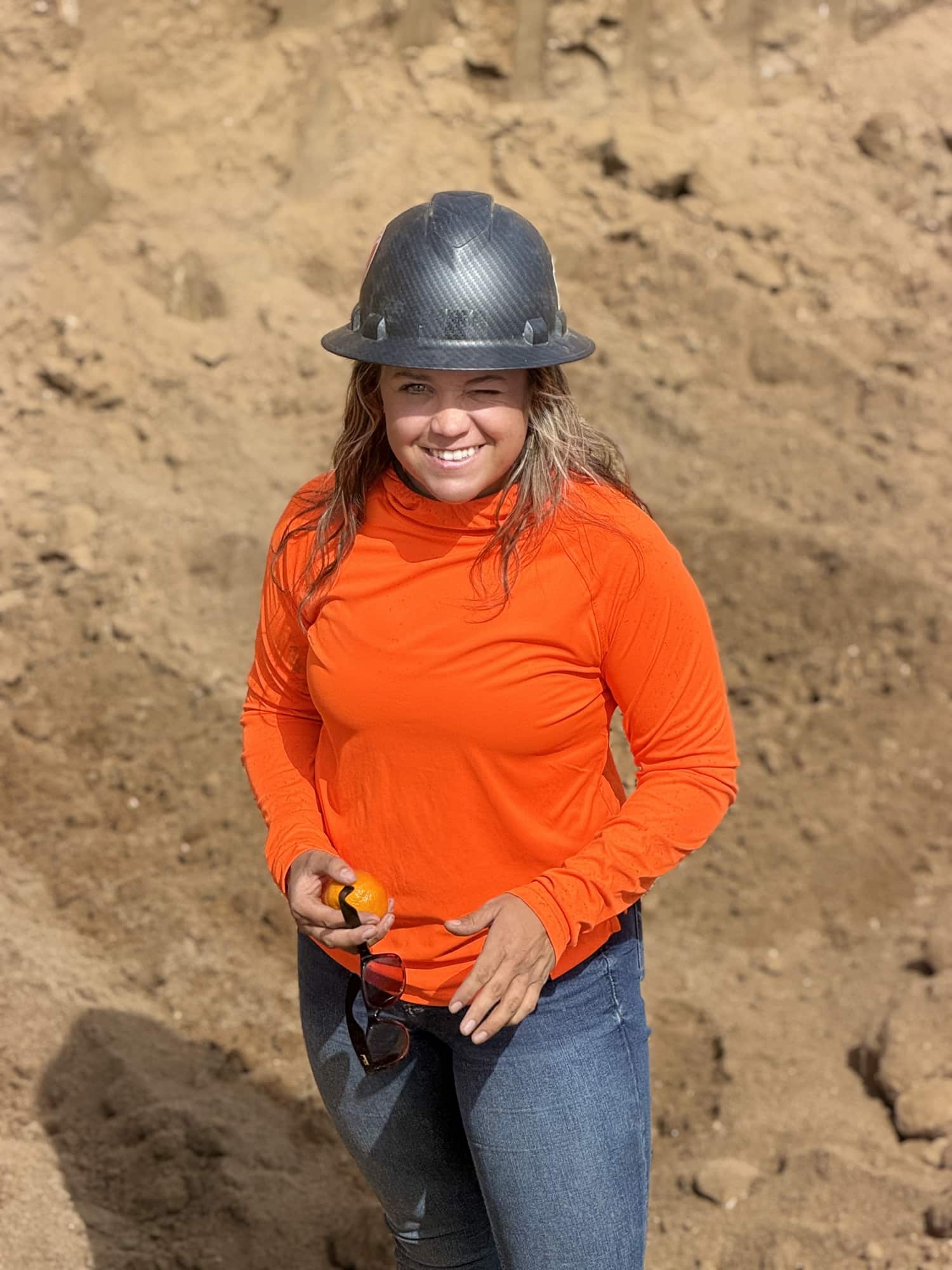 Worker in hard hat and safety shirt on a dirt job site